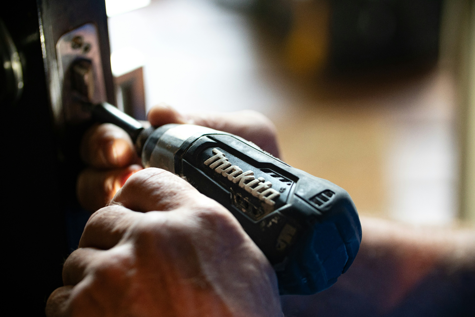 Ohana handyman installing hardware with a Makita drill