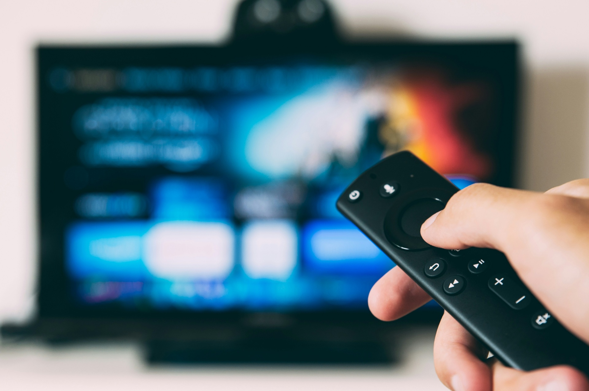Remote pointed at a TV — programming, streaming, and surround sound setup